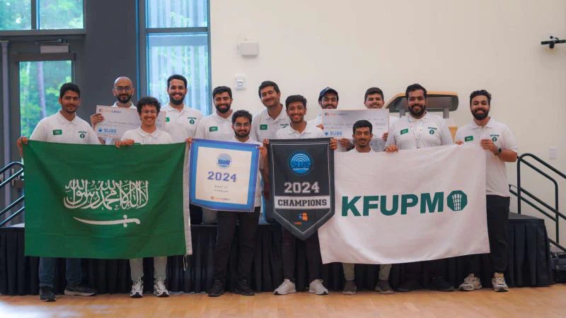 Picture of the UAS2030 team holding up the Saudi Arabian flag, team flag, and a 1st place winner check